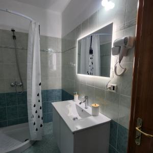 une salle de bain avec un lavabo et une douche avec un miroir dans l'établissement SunSea apartment, à Saranda