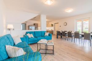 a living room with a blue couch and a dining room at VILLA DEI VENTI NORTH by Curtiaffitti in Pianello Del Lario