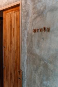 清邁的住宿－Woo Ma Ca Moo，一座有木门的建筑,字迹在墙上停下来
