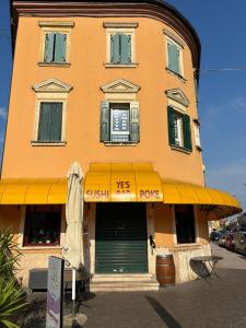 a building with a yellow awning in front of a store at Affittacamere Valentina in Verona +13 photos