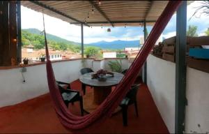 eine Hängematte auf einem Balkon mit einem Tisch und Stühlen in der Unterkunft Departamento Privado en el Centro de Valle in Valle de Bravo