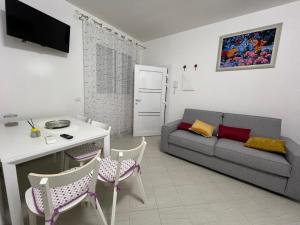 a living room with a couch and a table and chairs at Palazzo Nicole in Adria