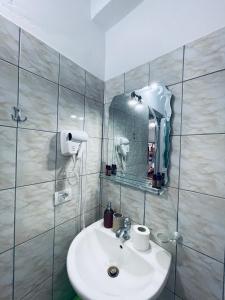 a bathroom with a sink and a mirror at Guesthouse Dollomaja Ksamil in Ksamil