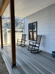2 chaises assises sur la terrasse couverte d'une maison dans l'établissement Canterbury Suites B&B, à Bar Harbor