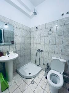 a bathroom with a toilet and a sink at Guesthouse Dollomaja Ksamil in Ksamil