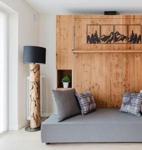 a living room with a couch and a wooden wall at PINZOLO MOUNTAIN LODGE in Pinzolo