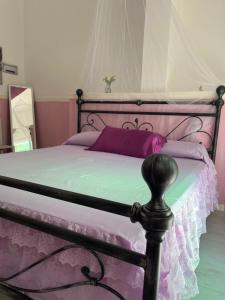um quarto com uma cama com almofadas roxas em Casa di vacanza "San Nicola" em Olbia