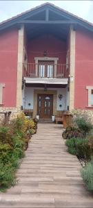 een roze gebouw met een loopbrug naar een deur bij Alojamientos Marte casa rural in Suances
