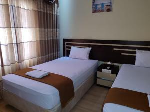 Dos camas en una habitación de hotel con dos en H.V HOTEL BANDARA, en Gorontalo
