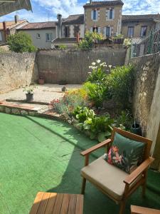 um pátio com uma cadeira e um jardim em Appartement en rez de jardin tout équipé em Fleurance
