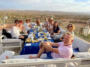 a group of people sitting around a table at Hotel Kasbah Ennakhile - Authentic Stay in Nkob in Nkob