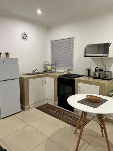 ネルスプロイトにあるSweet Home Alibamaのキッチン(白い冷蔵庫、テーブル付)