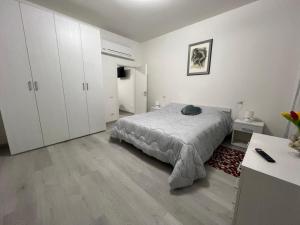 biała sypialnia z łóżkiem i białymi szafkami w obiekcie Palazzo Nicole w Adrii