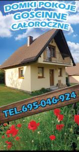 a magazine cover of a house with red flowers at Domki Agata in Ostrzyce