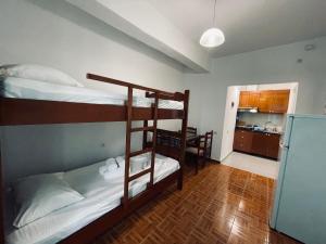 a room with two bunk beds and a kitchen at Guesthouse Dollomaja Ksamil in Ksamil