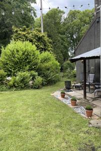 a backyard with a patio with a bench and plants at Stunning 2-bedroomed Cottage in Cockermouth