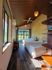 sypialnia z 2 łóżkami i wentylatorem sufitowym w obiekcie Chay Moutain Valley Bugalow w mieście Ninh Binh