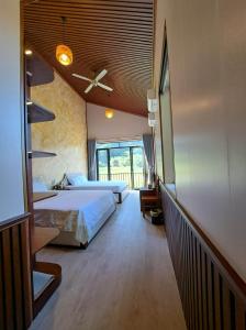 sypialnia z 2 łóżkami i wentylatorem sufitowym w obiekcie Chay Moutain Valley Bugalow w mieście Ninh Binh