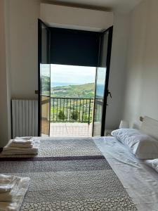 1 dormitorio con cama grande y ventana grande en La Foresteria- Azienda agricola Garra, en Mutignano