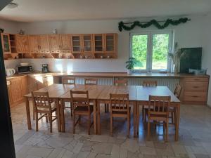 une cuisine avec une grande table et des chaises en bois dans l'établissement Dwór pod Sosnami Kaszuby, à Ostrzyce