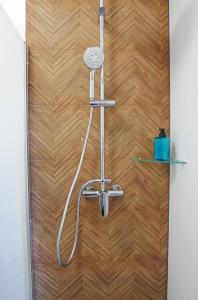 a shower in a bathroom with a wooden wall at Alda in Pyrzowice