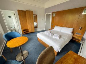 a hotel room with a bed and a table and chairs at The New England Hotel in Boston