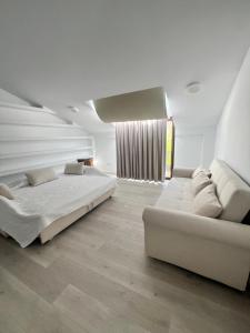 a white bedroom with a bed and a couch at Canaan Boutique Hotel Ronda in Ronda +64 photos