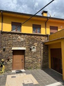 a stone building with a brown door and a building at Casa de Campo - Vila Boa in Vila Boa