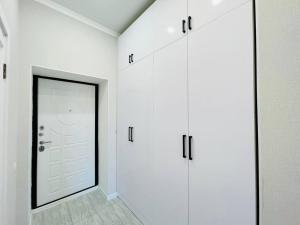 a room with white cabinets and a white door at Manhattan 5 Astana city in Taldykolʼ