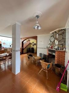 a living room with a fireplace and a table and chairs at Casa de Campo - Vila Boa in Vila Boa