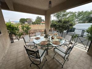eine Terrasse mit Tisch und Stühlen auf einem Balkon in der Unterkunft Labrini's House in Vélon