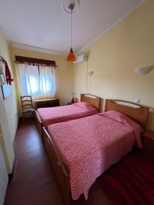 two beds in a hotel room with pink sheets at Casa de Campo - Vila Boa in Vila Boa