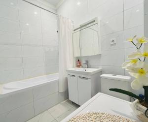 a white bathroom with a sink and a bath tub at Manhattan 5 Astana city in Taldykolʼ