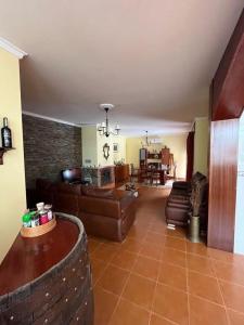 a living room with leather furniture and a brick wall at Casa de Campo - Vila Boa in Vila Boa