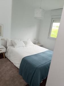 Una cama blanca en una habitación blanca con una ventana. en Bahía de Miño, en Miño 14 fotos más