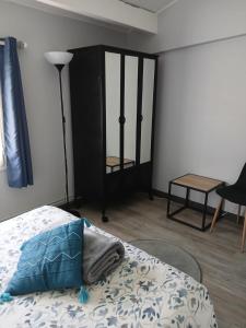 a bedroom with a bed with a blue pillow on it at Appartement indépendant privatif avec jardin in Le Crès