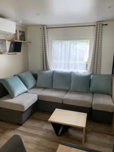 salon z kanapą i oknem w obiekcie MH 008 Bora Bora sur emplacement exceptionnel en lisière de forêt dans camping 4 étoiles w mieście Saint-Julien-en-Born