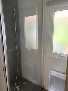 łazienka z prysznicem i szklanymi drzwiami w obiekcie MH 008 Bora Bora sur emplacement exceptionnel en lisière de forêt dans camping 4 étoiles w mieście Saint-Julien-en-Born +8 zdjęć