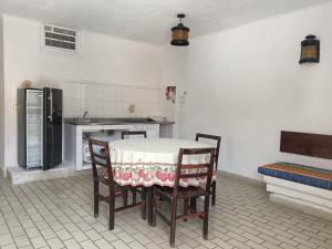 a kitchen with a table and chairs and a refrigerator at Suites La Audiencia in Manzanillo