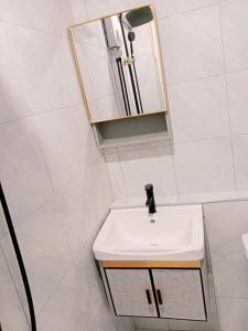 een badkamer met een witte wastafel en een spiegel bij STP apartment 2rd floor in Patong Beach