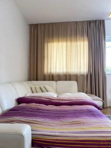 duże łóżko w sypialni z oknem w obiekcie Apartmani Andric w mieście Trebinje