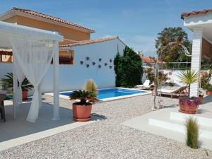 un patio trasero con piscina y una casa en Villa Ana en Vinarós