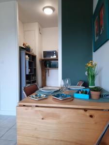 a kitchen with a table with plates and wine glasses at Horizon Marin accès direct plage in Cabourg