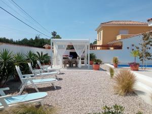 a patio with white chairs and a gazebo at Villa Ana in Vinarós