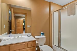 a bathroom with a toilet and a sink and a shower at 666 Disciples Village Condo in Boyne Falls +25 photos