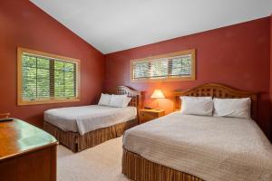 two beds in a room with red walls at 666 Disciples Village Condo in Boyne Falls