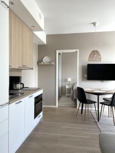 a kitchen with a table and a dining room at Sunny Beach Apartment Hiekkasärkät Kalajoki in Kalajoki