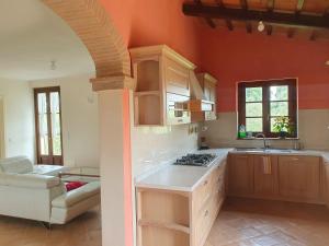 a kitchen with orange walls and a stove top oven at Villa Caini in Perugia