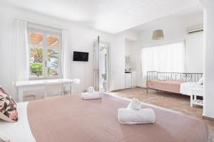 Ein weißes Zimmer mit einem Bett und einem Schlafzimmer. in der Unterkunft Fos Apartments Mykonos in Agios Ioannis Mykonos