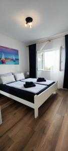 een slaapkamer met een groot bed in een kamer bij Apartments Ita - Postira in Postira